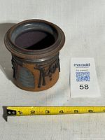 Front view showing full container and tape for scale