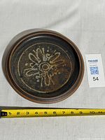 Top view of dish bowl showing glaze and floral design with measurement tape across diameter