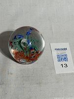 Front view of spherical paperweight showing internal marine figures