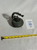 Top view of brass dragon censer with tape for scale