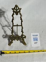 Front view of brass easel showing ornate design
