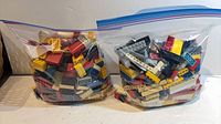 Two gallon zip-top bags filled with assorted vintage LEGO bricks and plates