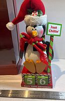 Front view showing penguin nutcracker, countdown blocks, sign, and ruler for scale