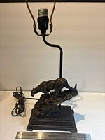 Full view of lamp showing socket, harp, mountain lion figure, base and power cord
