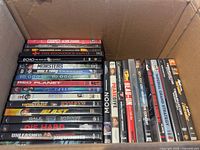 Open box showing two stacks of DVD cases with visible spines