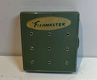 Front view of green Fishmaster fly box showing logo and vent holes