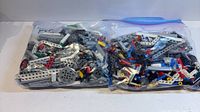 Two sealed Ziploc bags filled with assorted LEGO Technic pieces.