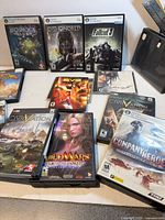 Overview showing multiple boxed PC games including BioShock 2, Dishonored, Fallout 3, Civilization titles, Guild Wars, Company of Heroes