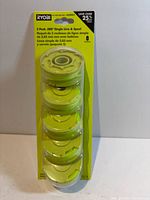 Front view of sealed blister pack showing five green spools