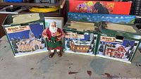 Three boxed Kringle Town buildings and Santa figurine