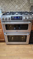 Front view of stainless steel GE Café gas range showing double oven doors and control panel