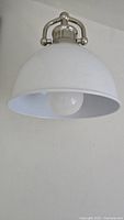 Side view of white dome shade wall sconce mounted on wall