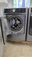 Maytag washer with door open revealing drum interior
