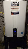 Front view of Navien tankless water heater showing display and label