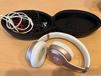 Headphones, open case, bundled audio cables visible
