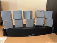 Four silver double-cube satellites placed on black center channel speaker