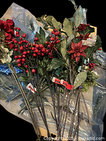 Assorted red berry picks, poinsettias and greenery on table