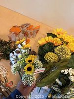 Spread of various artificial flower stems and ribbon bows on tabletop
