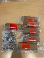 All eight Pottery Barn drapery hook packages with some hooks visible