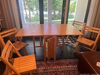 Table open with drop leaves extended and four chairs positioned around