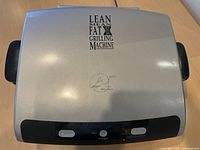 Closed grill showing brand logo and control panel