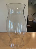 Full view of clear glass hurricane lantern on table