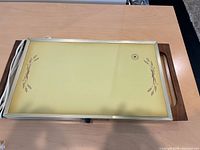 Top view of warming tray showing yellow glass surface with wheat design and wood handles