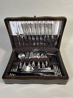 Full view of flatware set in open wooden chest