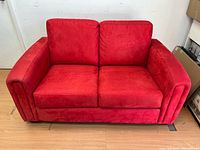Front view of red leather love seat showing cushions and arms