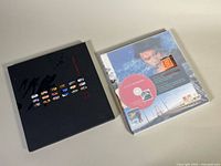 Both yearbooks closed, 2006 in dark slipcase, 2005 opened slipcase removed