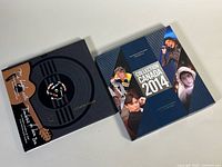 Front view of both stamp books with sleeves