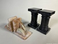 Black marble column pair beside light marble curved pair