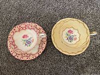 Overhead of both cup and saucer sets showing patterns and floral centers