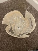 Top view of translucent ruffled glass bowl showing form and interior sticker