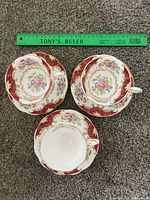 Three teacups each on its saucer displayed beside 12-inch ruler for scale