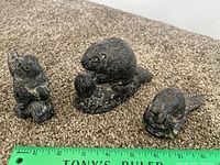 Front view of all three figurines with ruler for scale