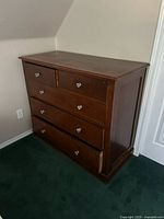 Front view of solid wood dresser showing overall form and glass knobs
