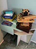 Stacked boxed games and wooden board sets on shelf