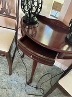 Console table drawer open beside chairs and lamp bases visible