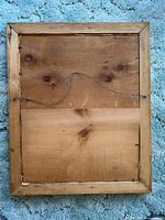 Rear view showing wooden backing and hanging wire