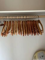 Row of mixed-tone wooden suit hangers on closet rod