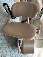 Beige padded stairlift seat with armrests and footrest