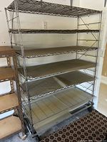 Full view of chrome wire shelving unit with six shelves and casters