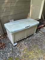 Closed Rubbermaid storage tote showing exterior wear and lid color