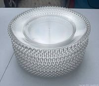 Stack of clear plastic charger plates showing hobnail beaded rims