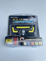 Front view of sealed Bell + Howell Solar Bionic Light package showing LEDs and motion sensor