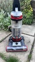 Front view of Bissell CleanView upright vacuum showing clear bagless canister and base