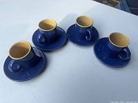 Four espresso cups with saucers, top angle