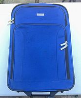 Front view of royal blue Embark suitcase showing exterior pockets and zippers