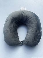 Front view of gray U-shaped travel neck pillow showing plush velour fabric and overall shape